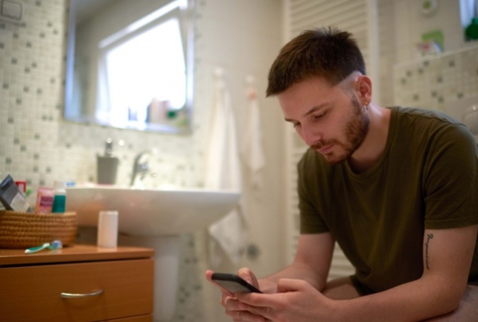 Врач рассказал, к чему может привести использование телефона в туалете